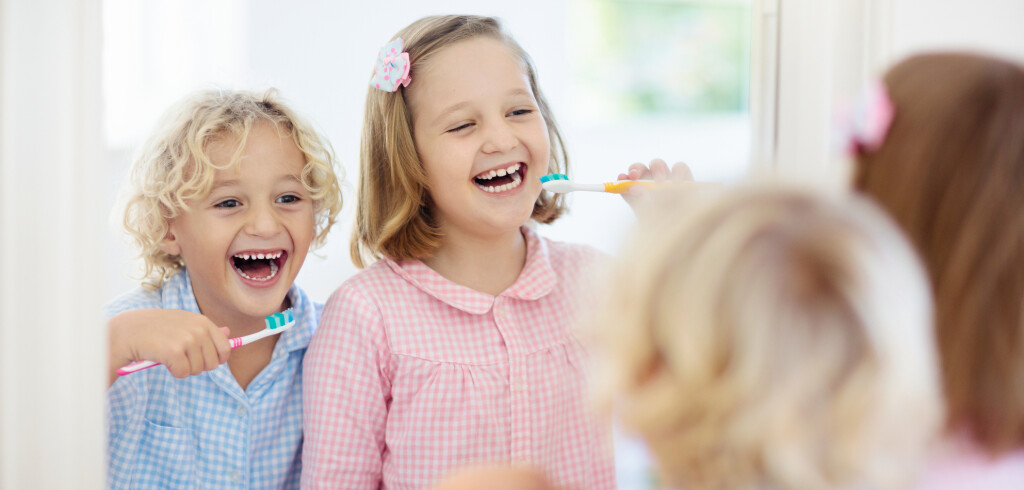 Child brushing teeth. Kids with toothpaste and brush. Dental and oral hygiene, care. Healthy daily routine for children. Kid after shower or bath at home. Girl and boy in pajamas with tooth paste.